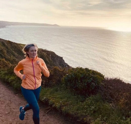 Becky corre al tramonto su una strada che costeggia il mare