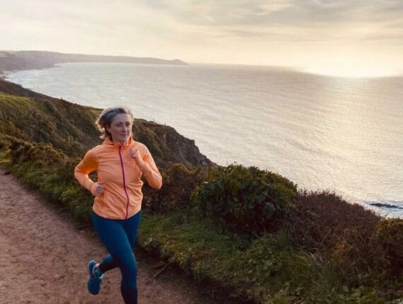 Becky corre al tramonto su una strada che costeggia il mare