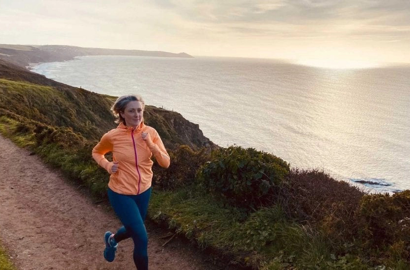 Becky corre al tramonto su una strada che costeggia il mare