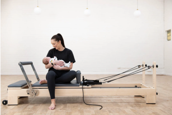 Emma Stallworthy seduta sul reformer con in braccio il suo bambino