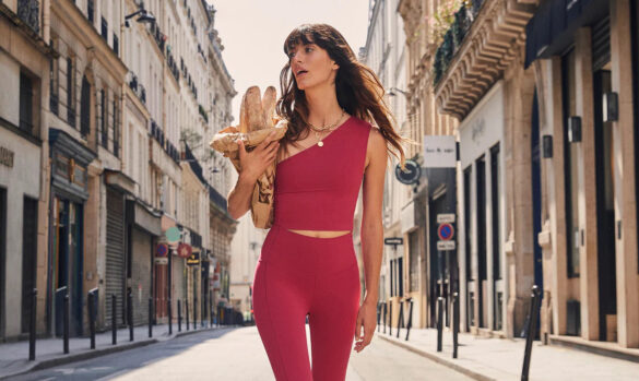 Modella con top e leggings fuscsia passeggia per strada