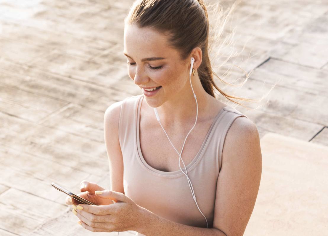 Ragazza in abbigliamento fitness guarda il cellulare