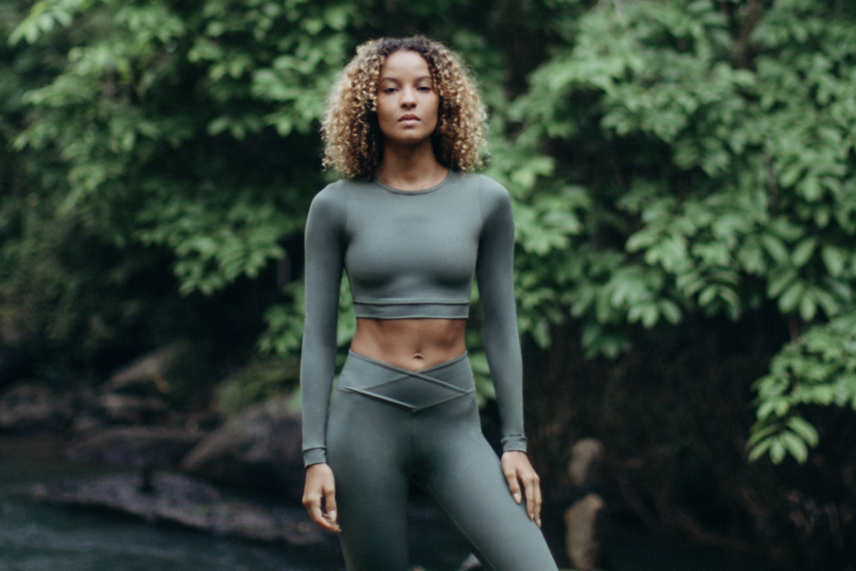 Ragazza con completo fitness verde immersa nella natura