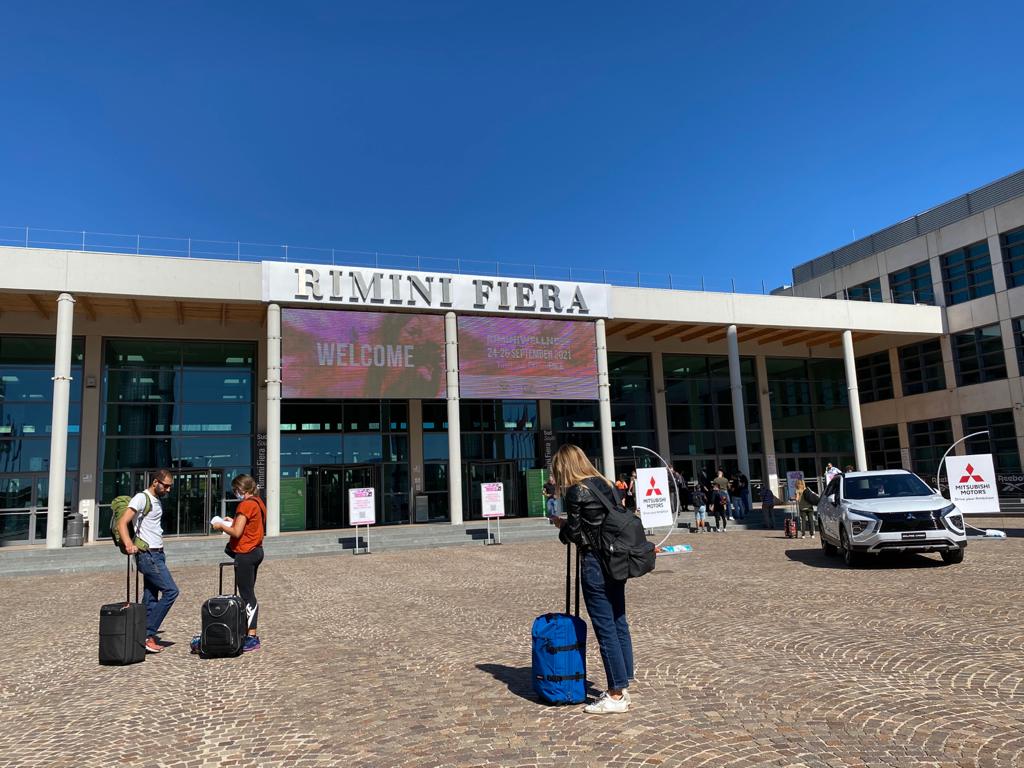 Ingresso Fiera di Rimini con alcune persone che arrivano con i l loro trolley